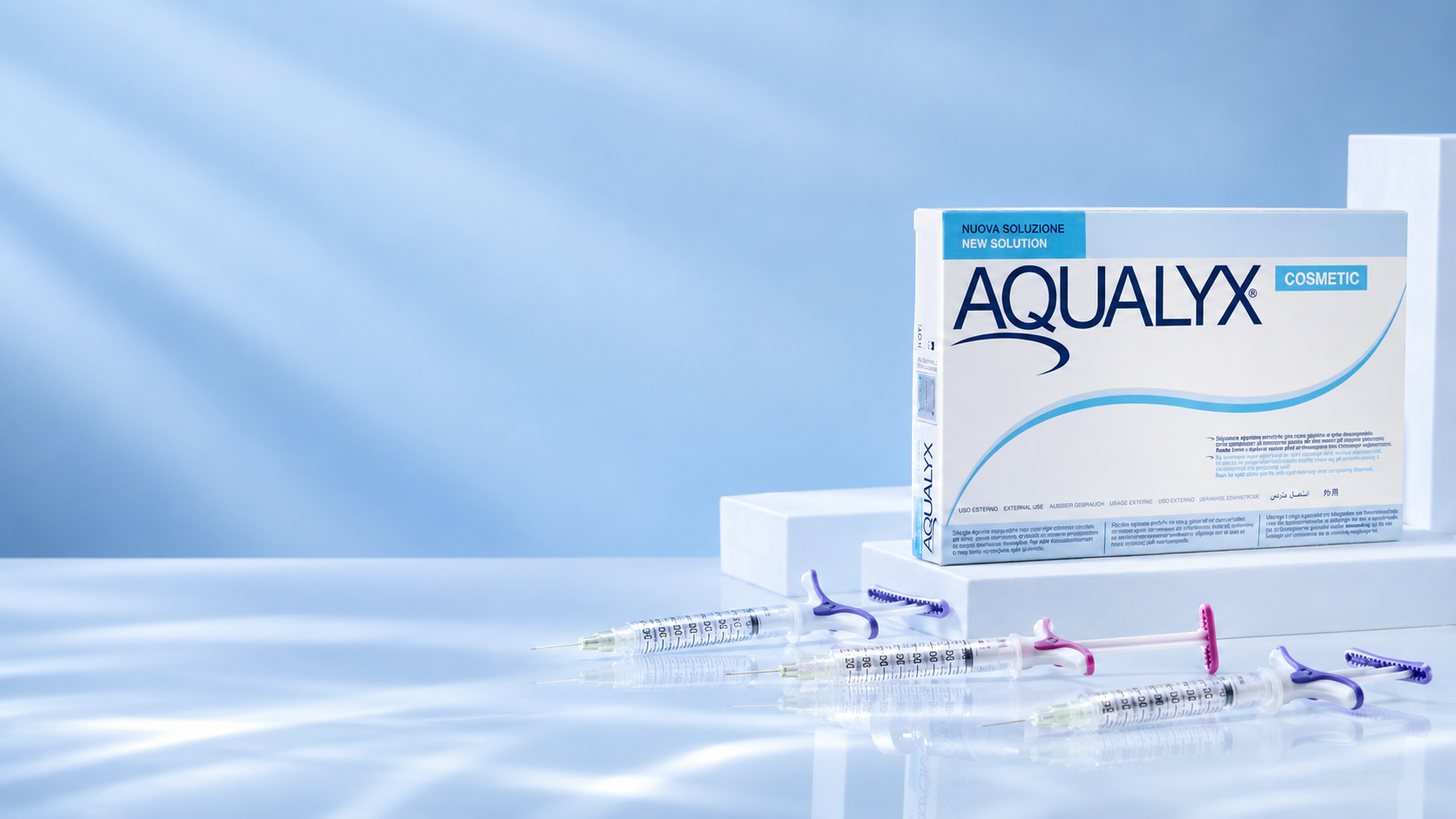 Aqualyx cosmetic box with three syringes on a reflective blue surface